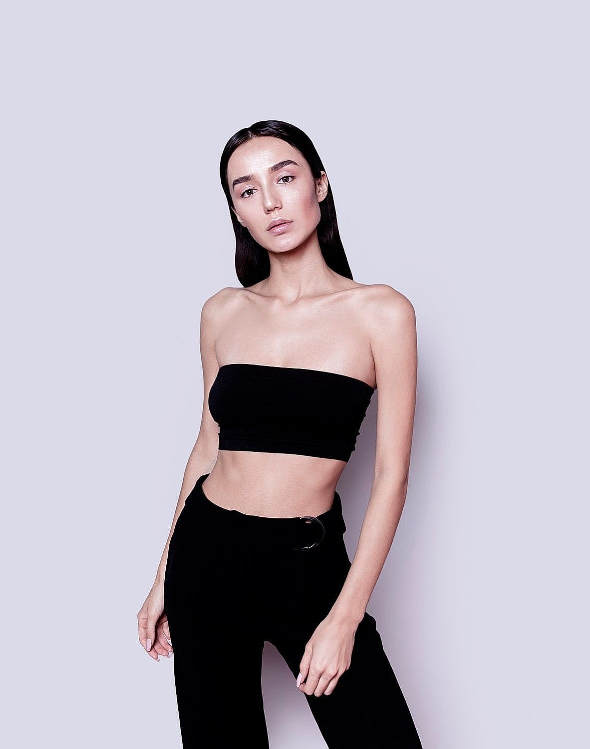 Model in black outfit with neutral background.