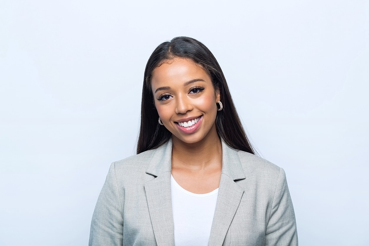 Smiling woman in a professional gray blazer.